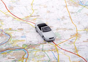 白色与红色和黄色道路标志着地图,城镇和城市表示,白色玩具车坐在中心