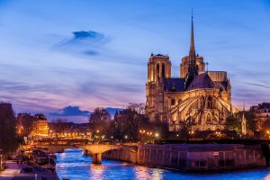 pre-fire的照片在巴黎圣母院大教堂,塞纳河在前景,后期日落的天空蓝色消失地平线上淡紫色